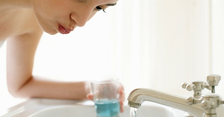 woman rinsing mouth with best natural mouthwash